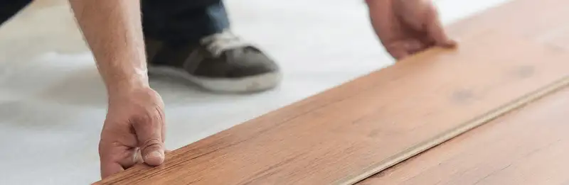 A professional installing laminate flooring in Fort Wayne, IN